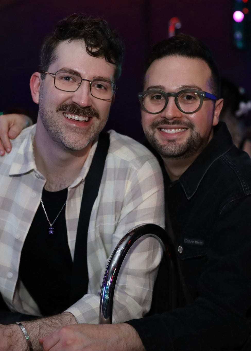 Two men with glasses posing for a photo at an event.