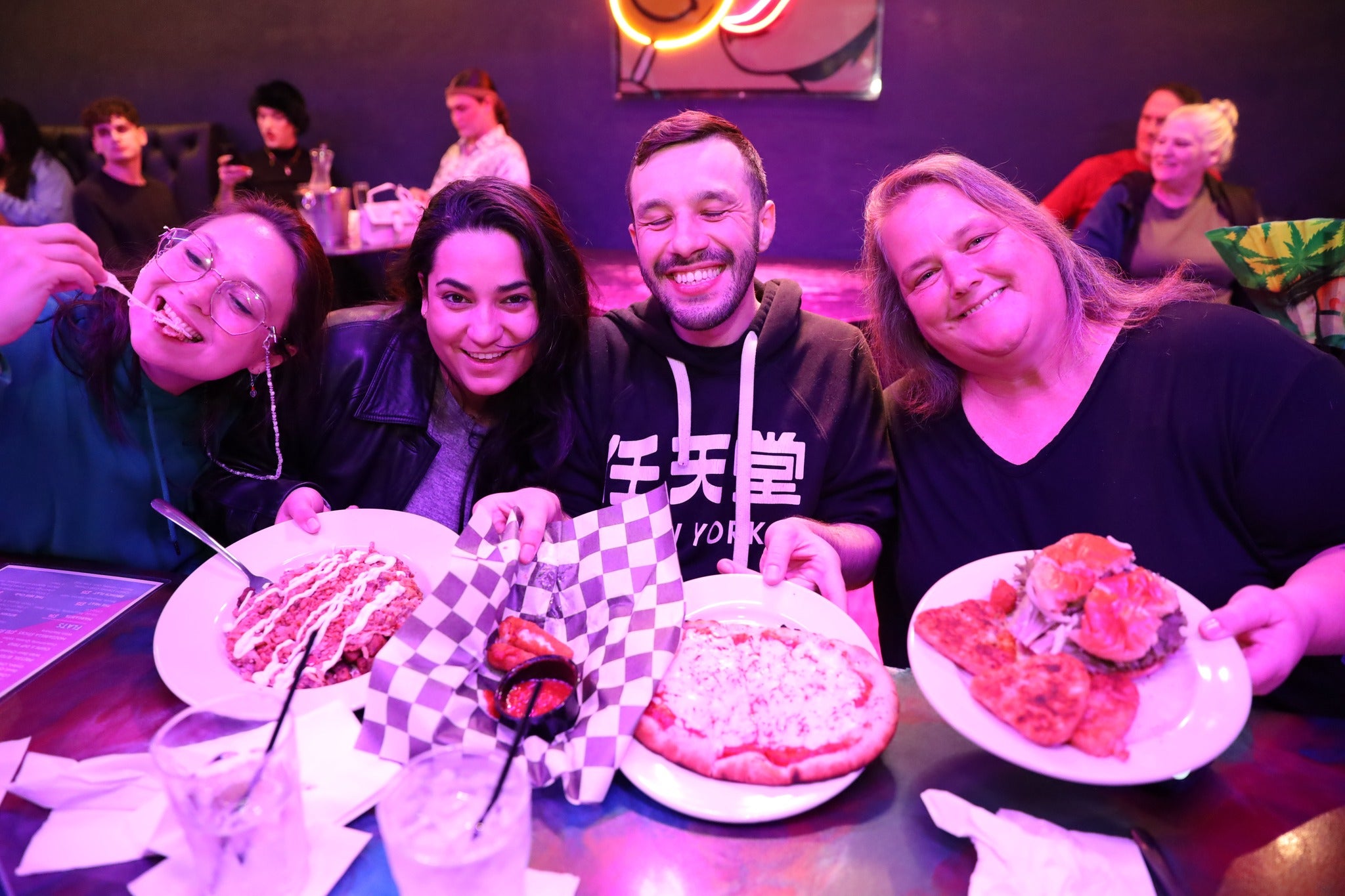 Group of people enjoying pizza and drinks in a casual setting